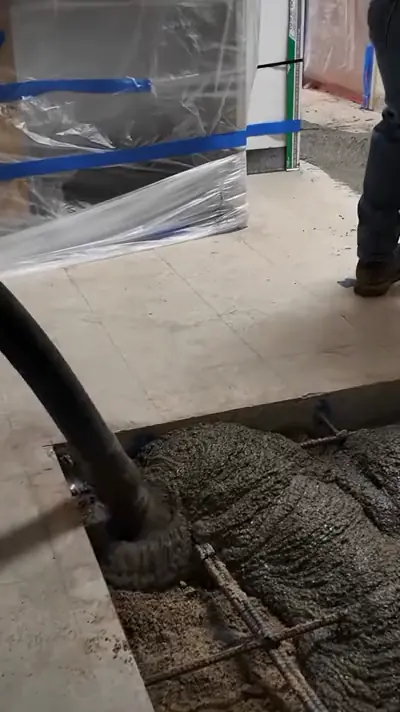Concrete hose and steel mesh on a taped-off floor slab